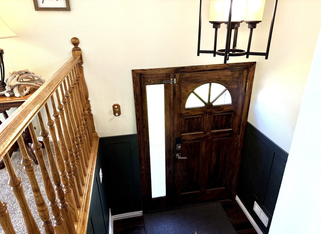 Foyer with a wainscoted wall and a decorative wall