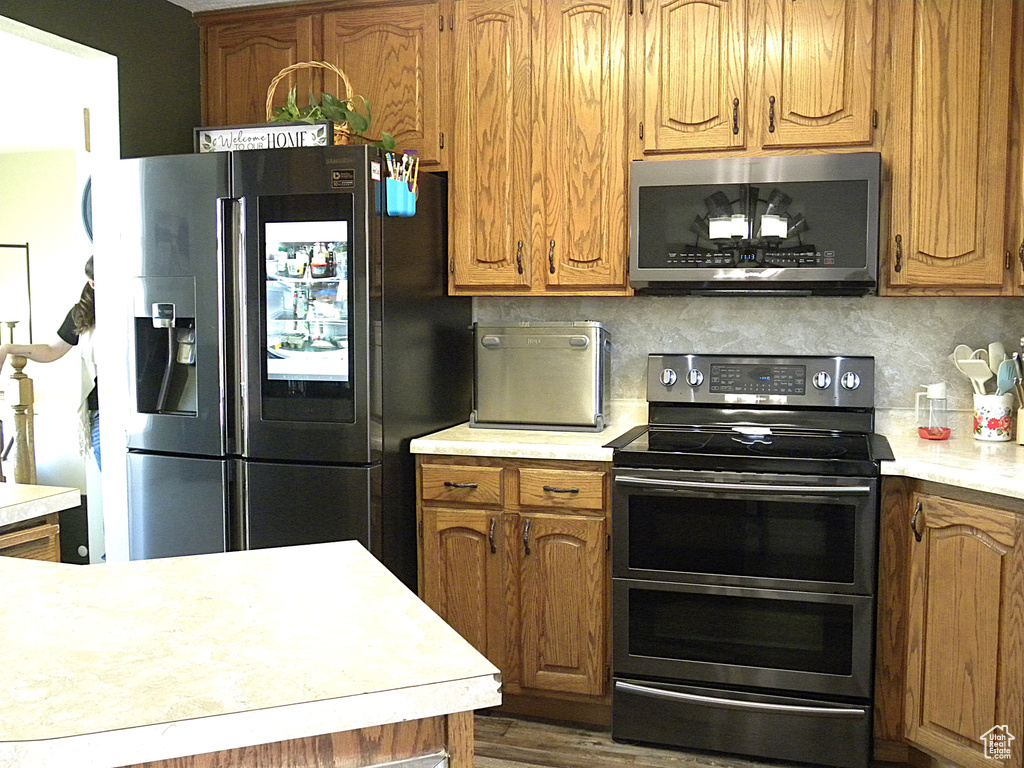 Kitchen with appliances with stainless steel finishes, light countertops, and tasteful backsplash