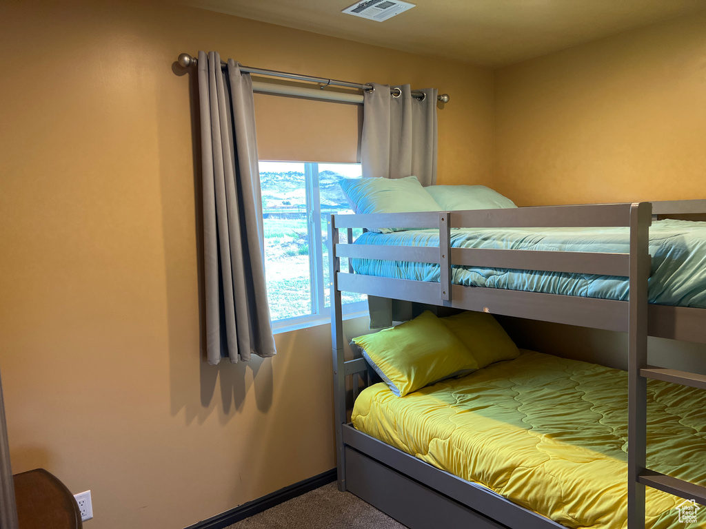 Bedroom featuring baseboards, visible vents, and carpet floors