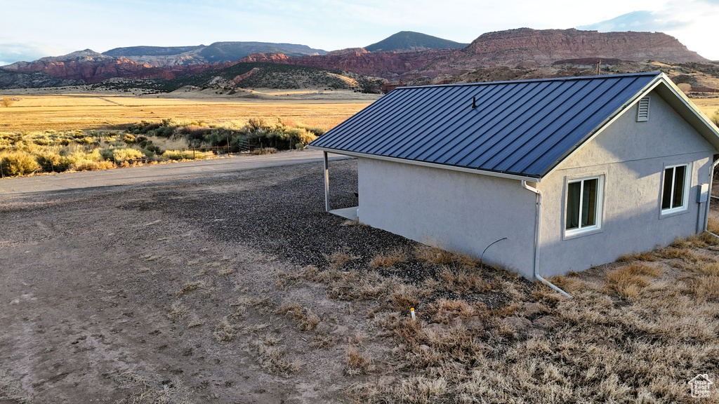 View of home's exterior with stucco siding, a standing seam roof, metal roof, and a mountain view