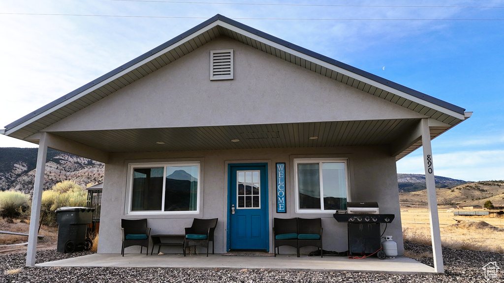 Rear view of property with a mountain view, an outdoor hangout area, and stucco siding