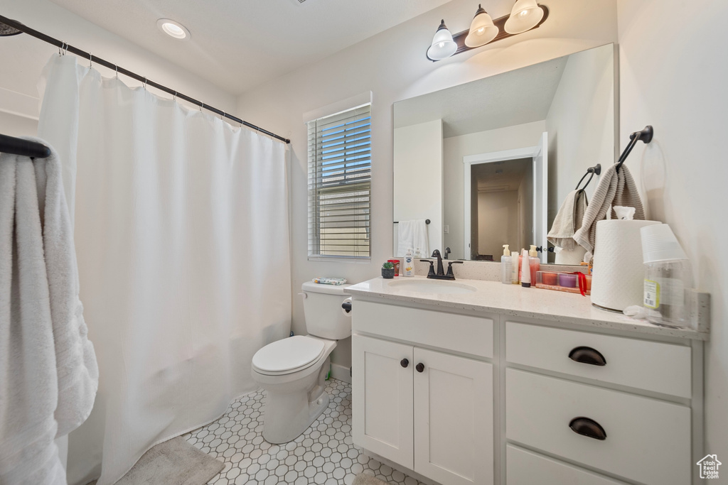 Full bath featuring shower / tub combo with curtain, toilet, and vanity