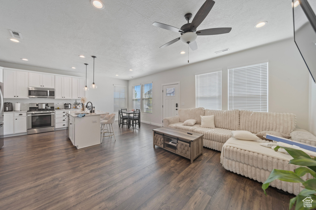 Living area featuring visible vents, a ceiling fan, dark wood-style floors, and recessed lighting