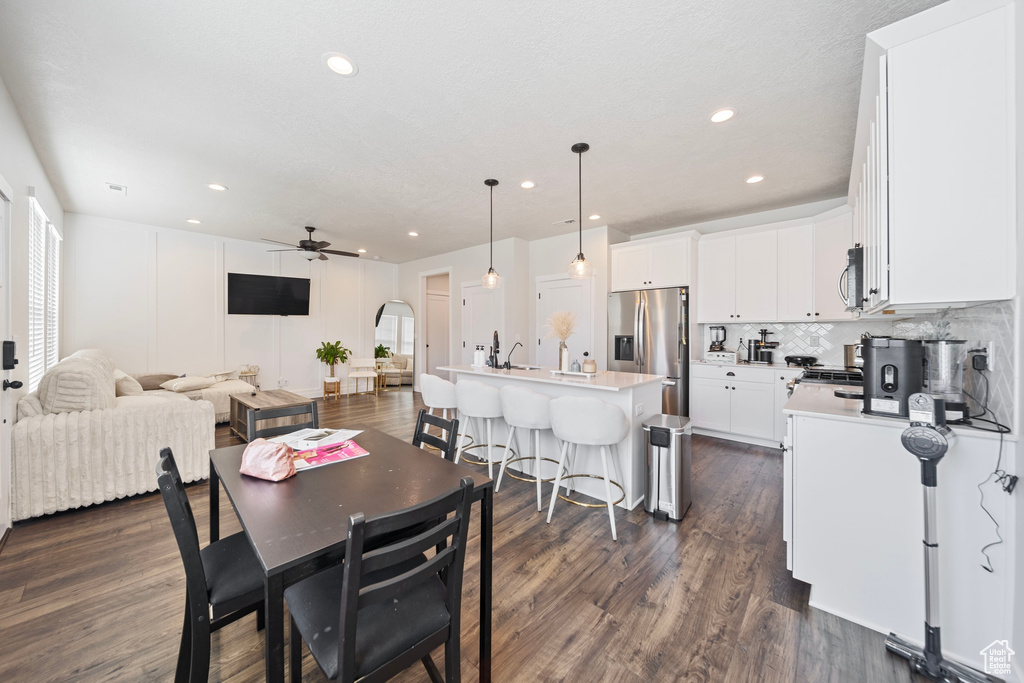 Dining space featuring recessed lighting, arched walkways, ceiling fan, and dark wood-style flooring