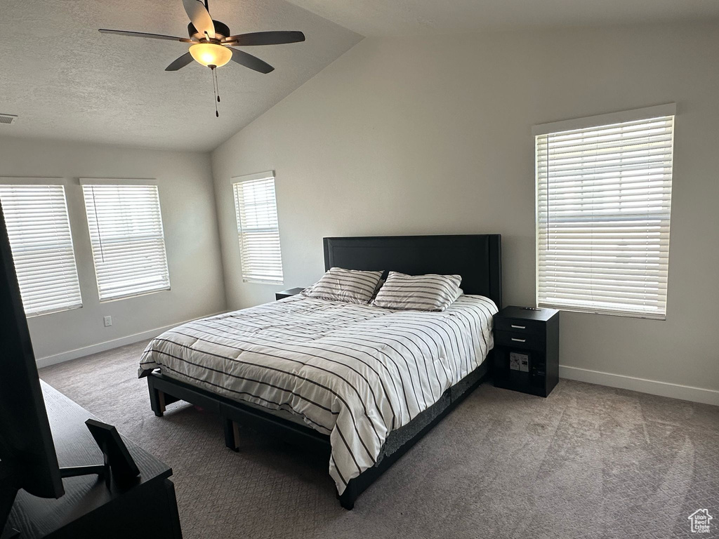 Bedroom with carpet flooring, a ceiling fan, baseboards, and lofted ceiling