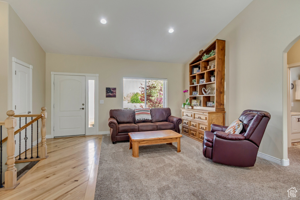 Living area with recessed lighting, arched walkways, wood finished floors, and baseboards