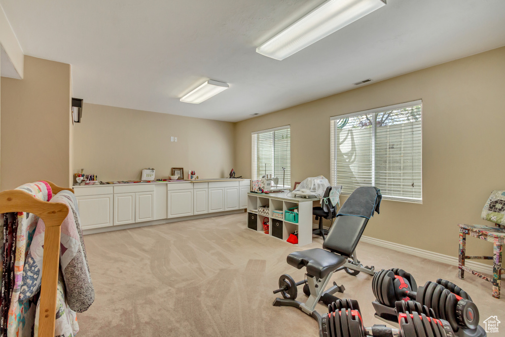 Workout area with visible vents, light colored carpet, and baseboards