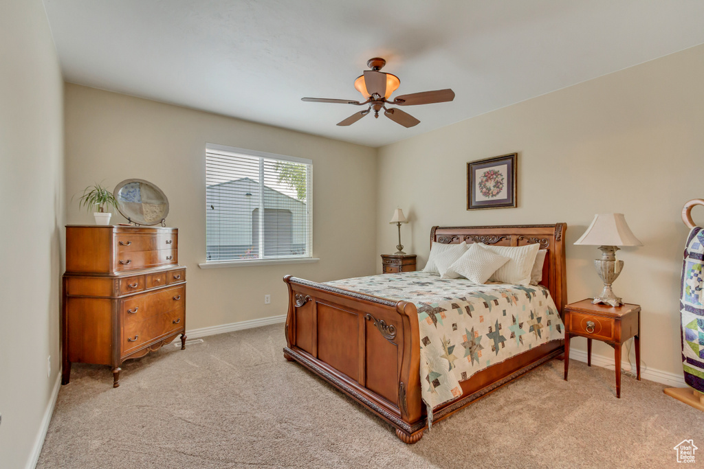 Bedroom featuring ceiling fan, baseboards, and light carpet