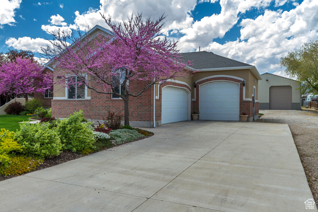 View of front of house featuring concrete driveway, an attached garage, and brick siding