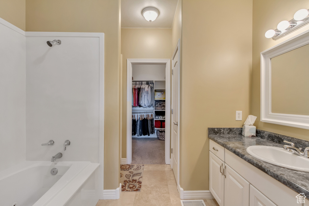 Bathroom featuring vanity, tile patterned flooring, and a walk in closet