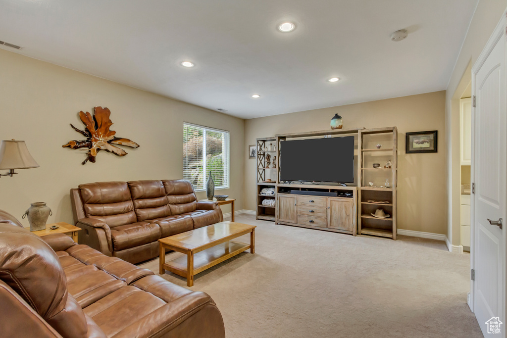 Living area with recessed lighting, light carpet, and baseboards