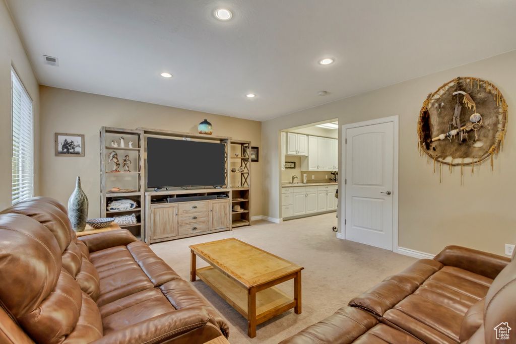 Living area with light colored carpet, visible vents, recessed lighting, and baseboards