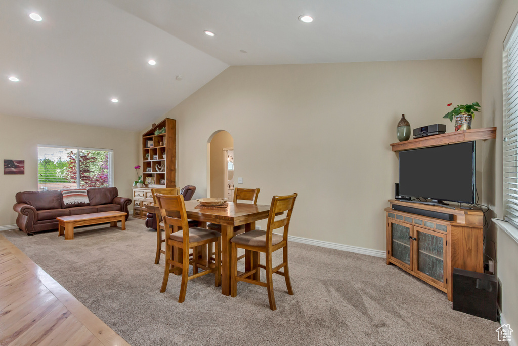 Dining room with light colored carpet, a healthy amount of sunlight, recessed lighting, and arched walkways