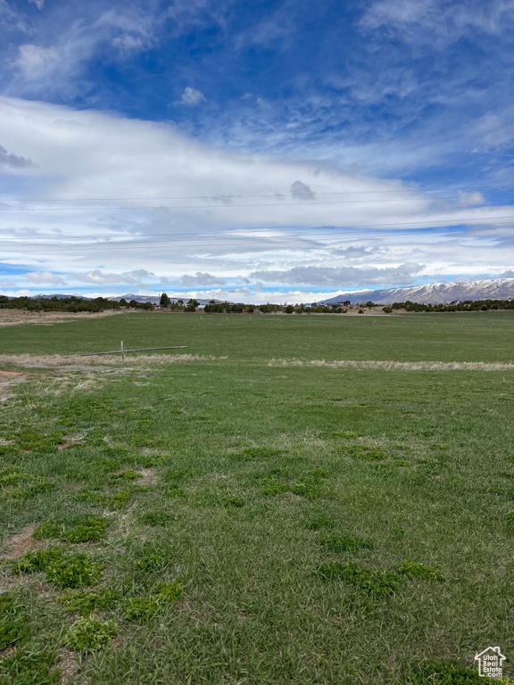 View of property's community with a lawn, a rural view, and a mountain view