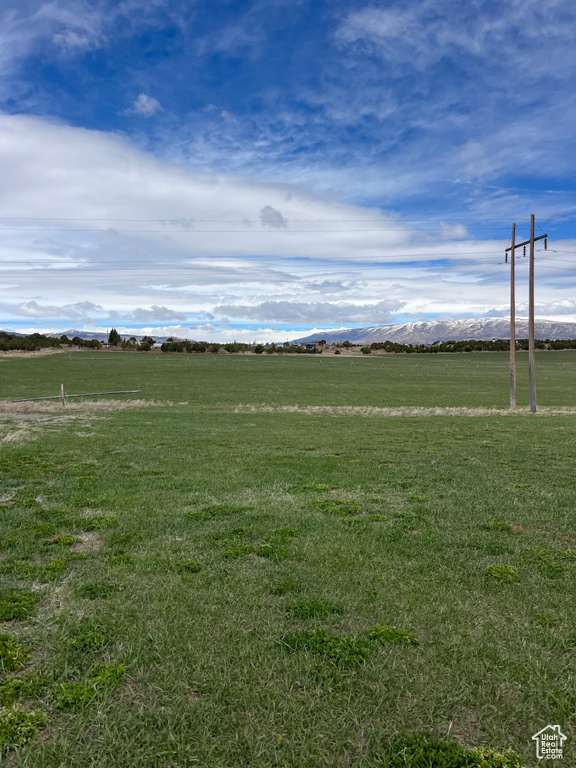 View of home's community with a rural view and a lawn