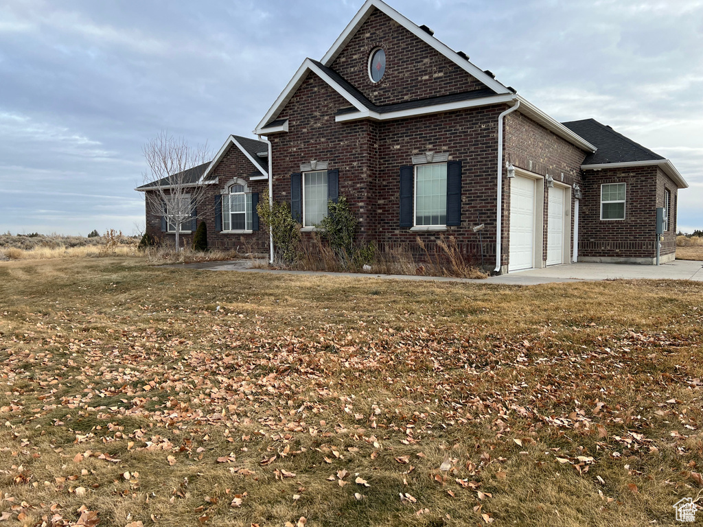 View of front of property featuring a garage and brick siding