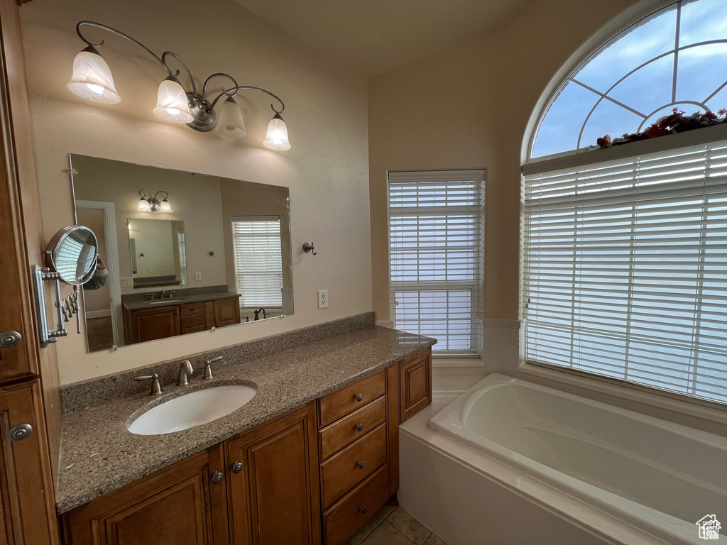 Full bathroom featuring a bath, tile patterned flooring, and vanity