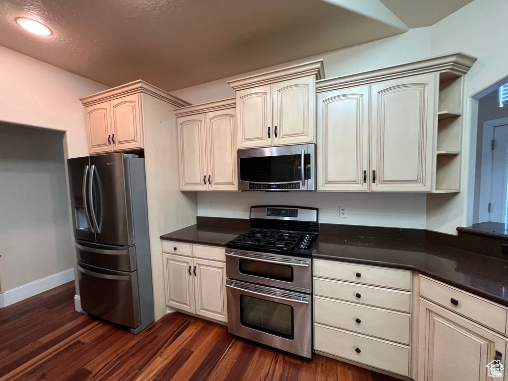 Kitchen featuring stainless steel appliances, recessed lighting, dark wood finished floors, and baseboards