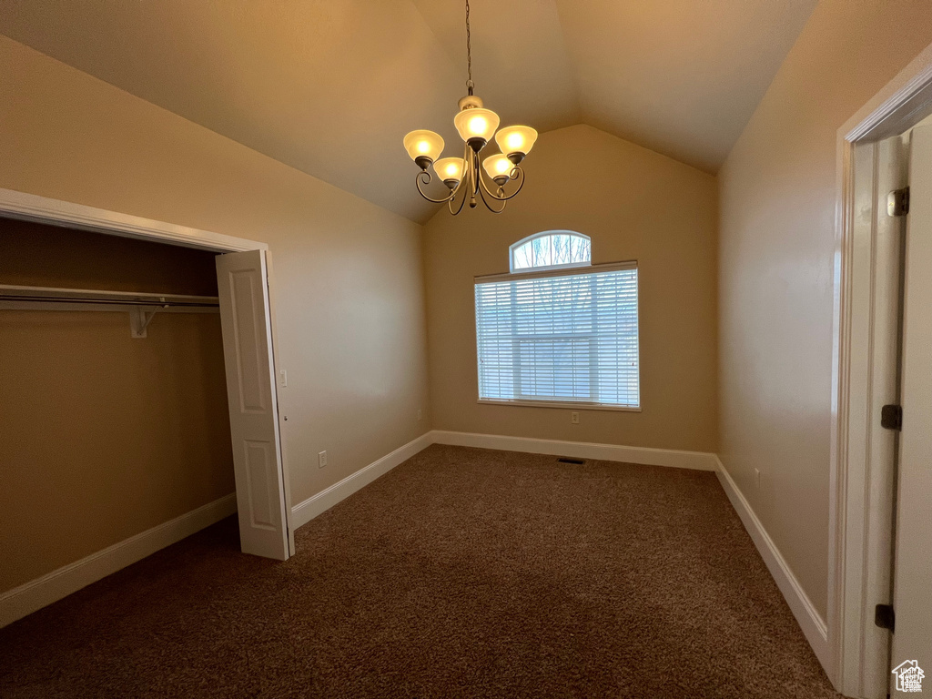 Unfurnished bedroom with a chandelier, baseboards, carpet, and vaulted ceiling