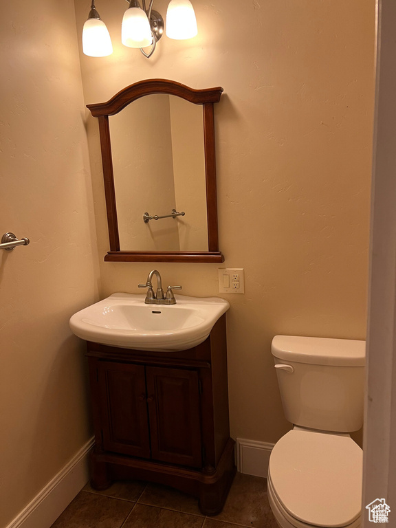 Bathroom featuring toilet, tile patterned flooring, vanity, and baseboards