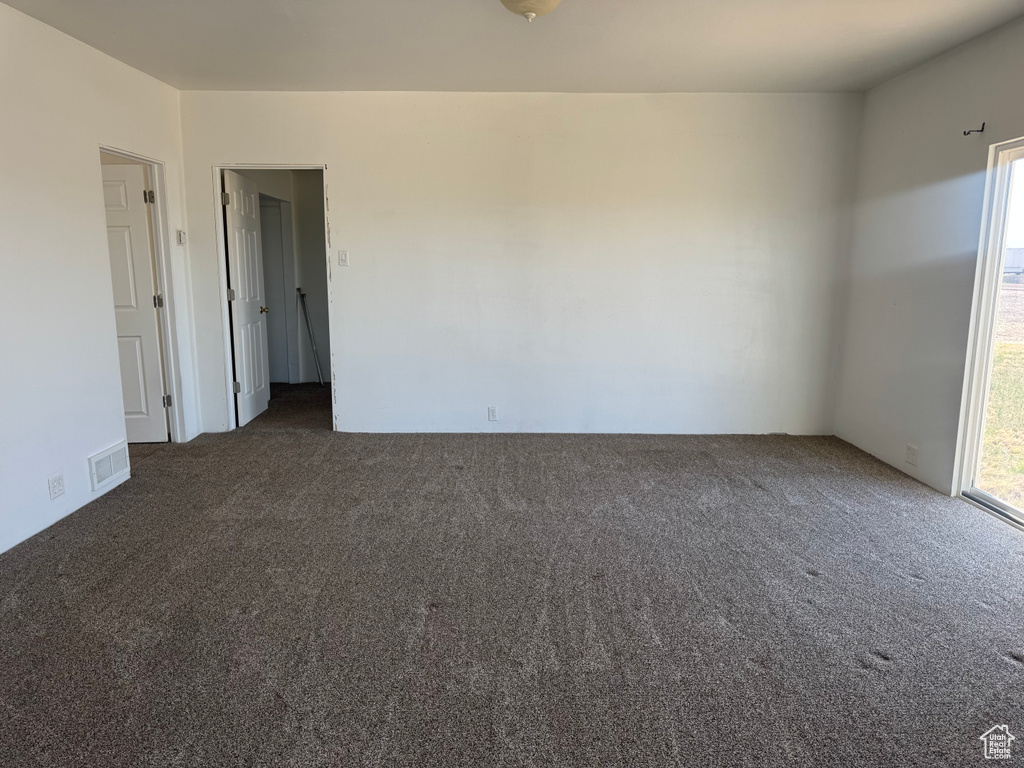 Empty room with visible vents and carpet