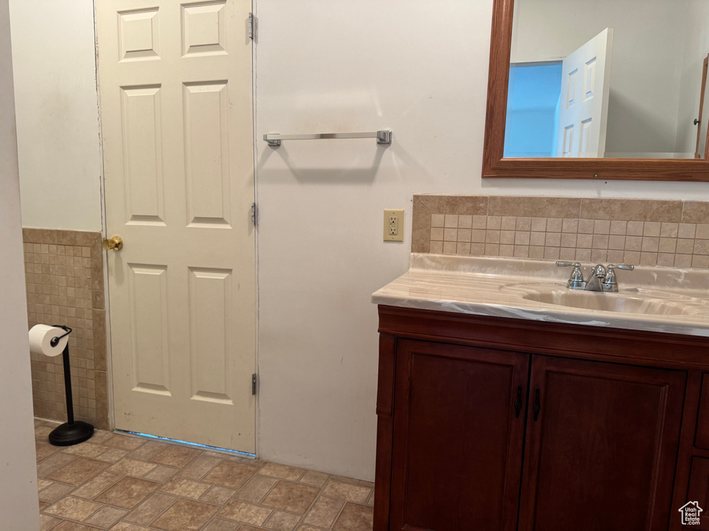 Bathroom with vanity and tile walls