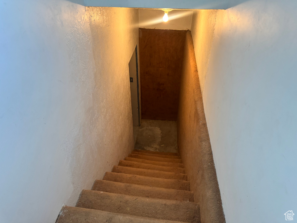 Stairs featuring a textured wall