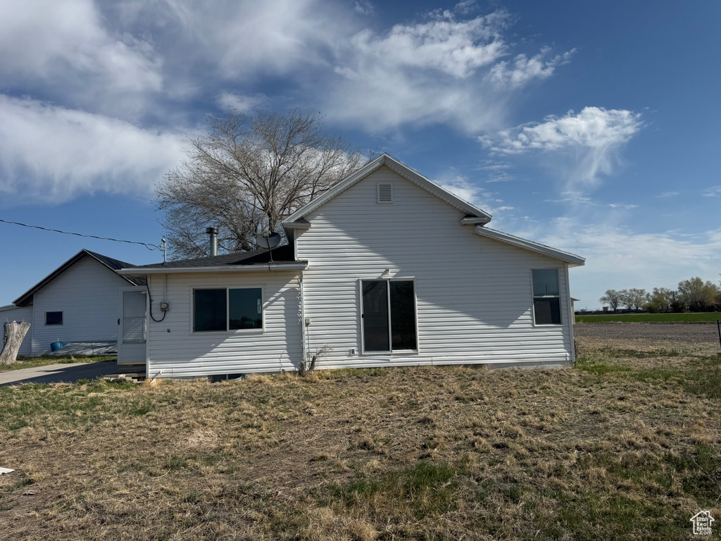 Back of house with a lawn