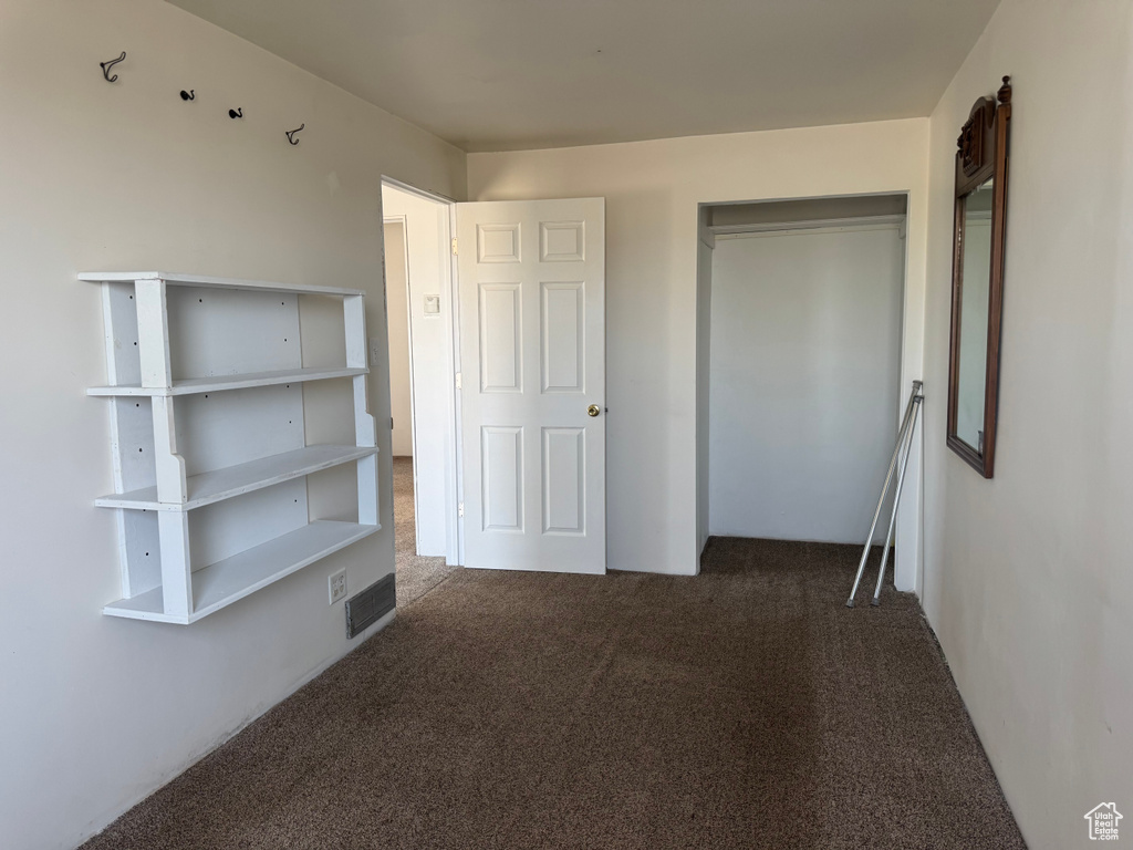 Unfurnished bedroom featuring visible vents, carpet floors, and a closet