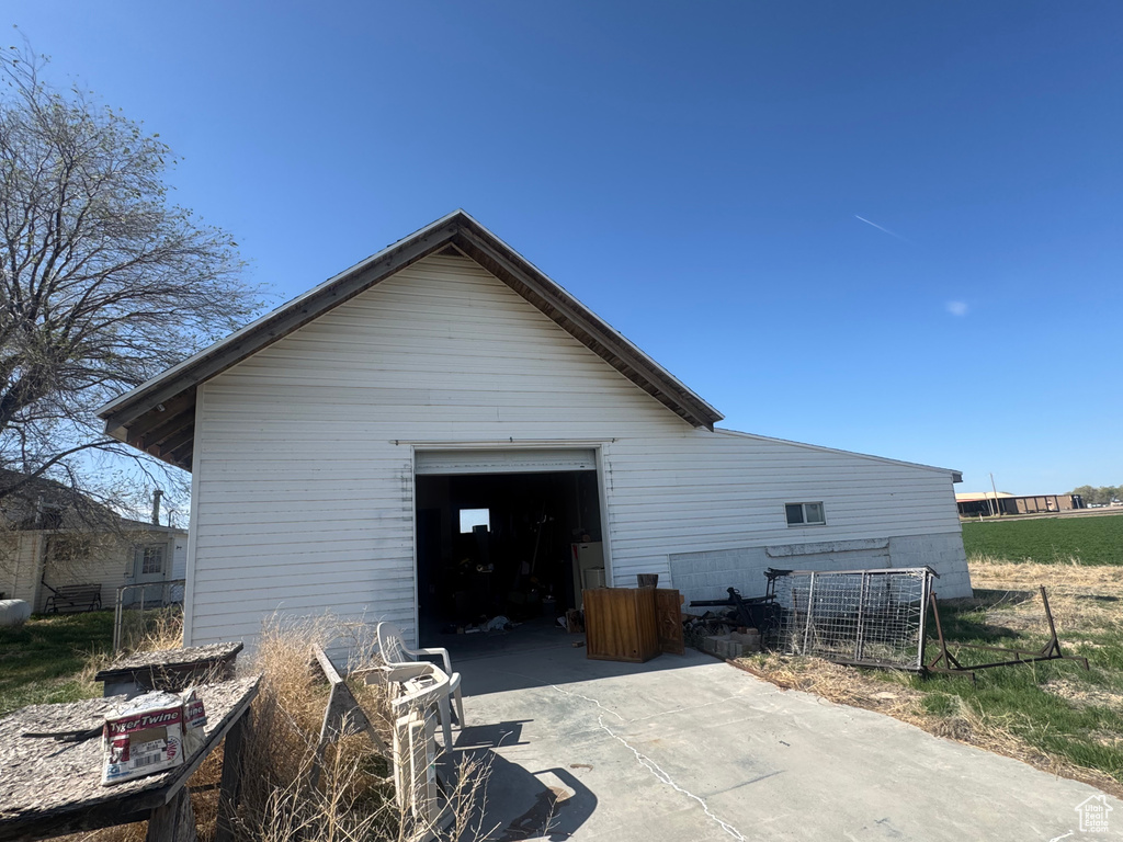 View of home's exterior featuring concrete driveway, an outdoor structure, fence, and a garage
