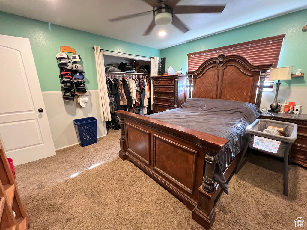 Carpeted bedroom featuring a ceiling fan and a closet