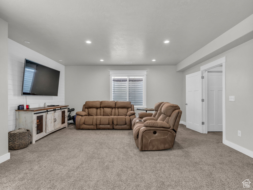 Carpeted living area with baseboards and recessed lighting