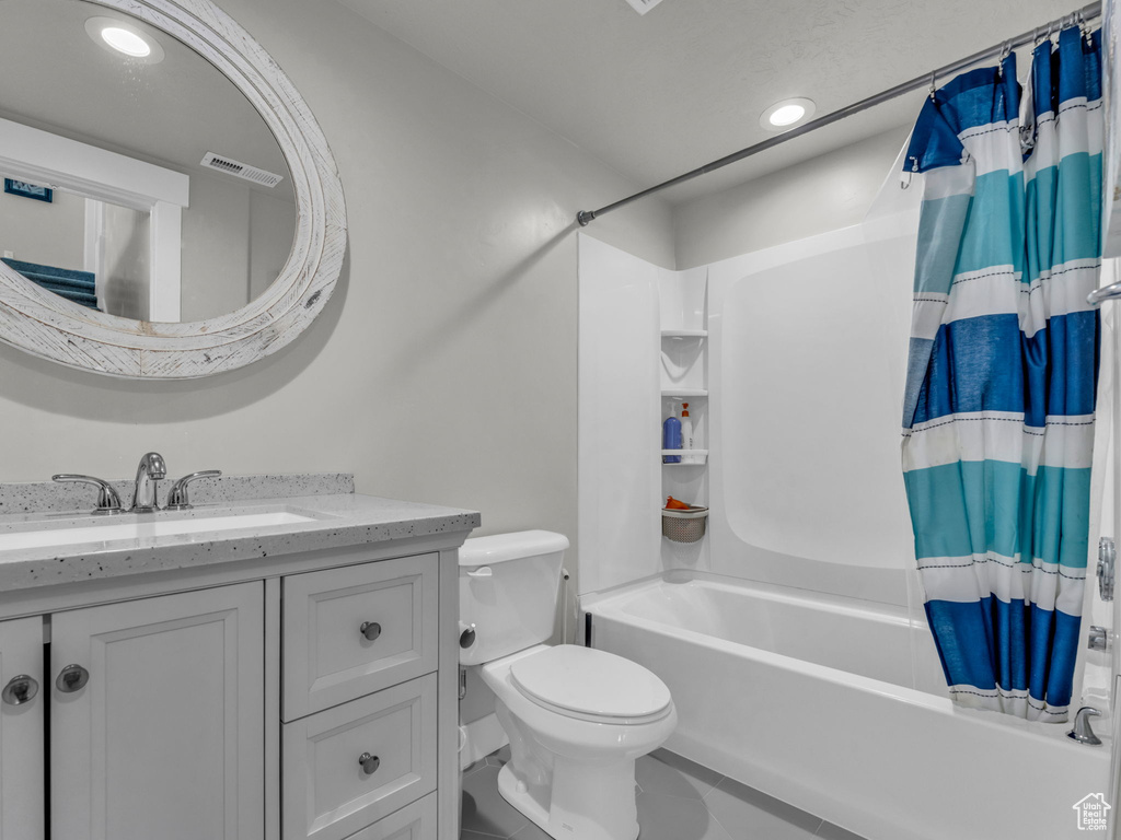 Full bathroom featuring tile patterned flooring, shower / bathtub combination with curtain, toilet, vanity, and visible vents