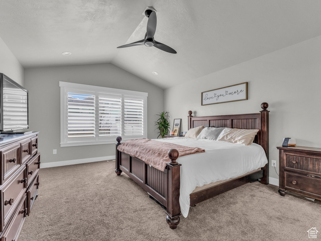 Bedroom with baseboards, a ceiling fan, light colored carpet, and vaulted ceiling