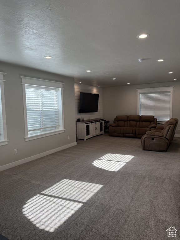 Carpeted living room featuring recessed lighting and baseboards