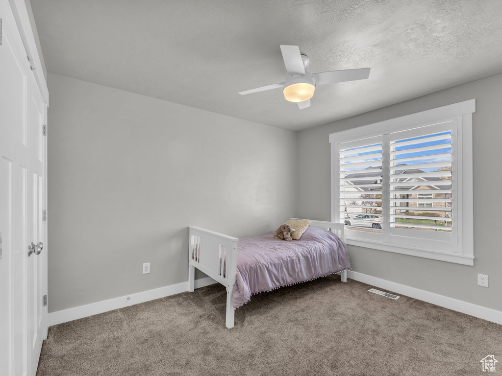 Bedroom featuring baseboards, visible vents, a ceiling fan, and carpet