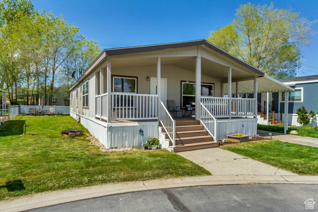 Manufactured / mobile home featuring a front yard and a porch