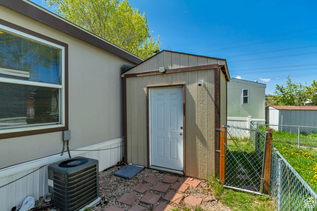 View of shed featuring fence and central air condition unit