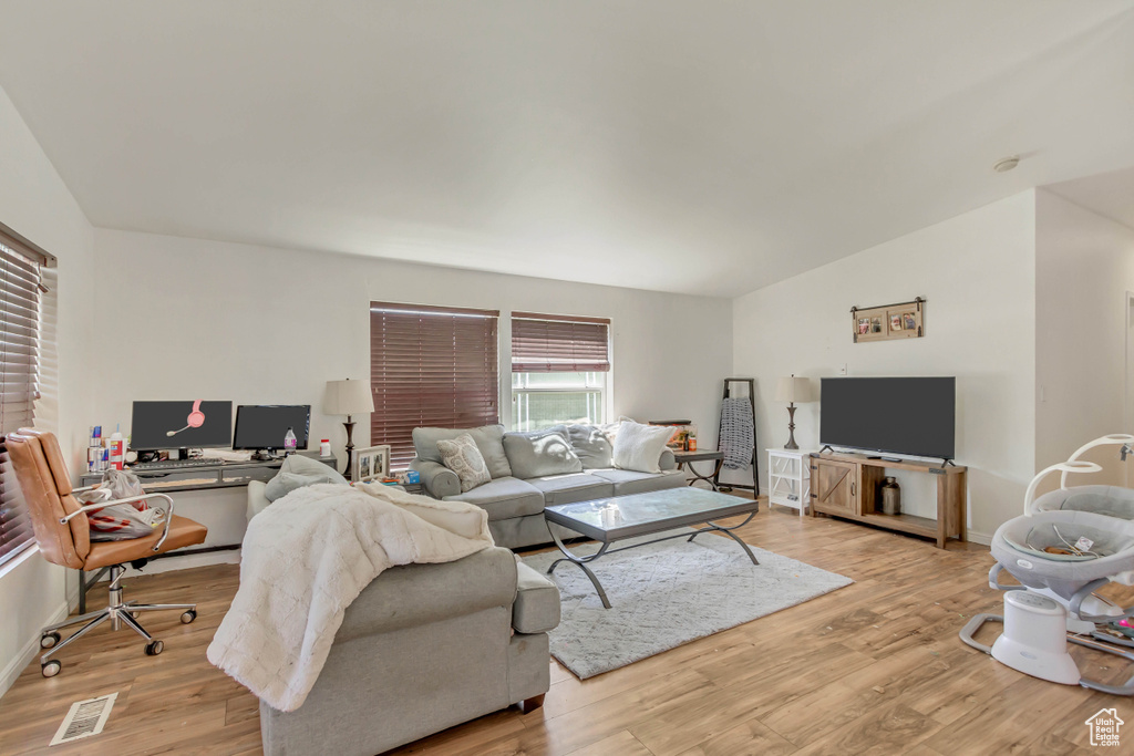 Living room featuring visible vents, light wood-type flooring, and baseboards