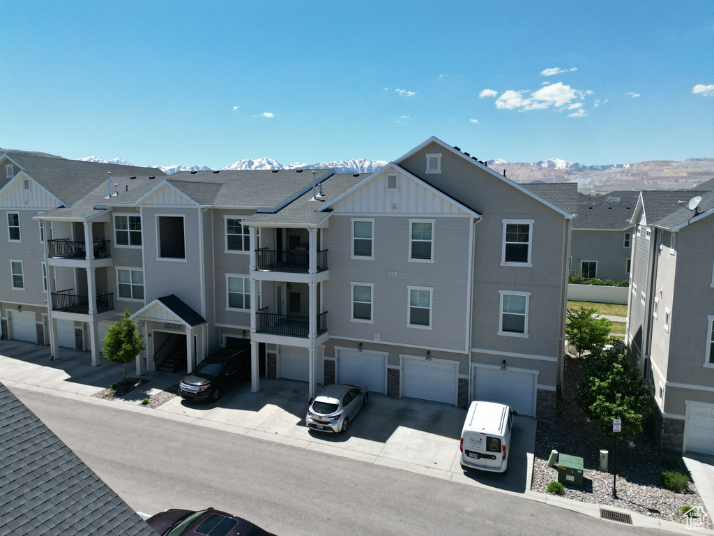 View of property featuring driveway, a mountain view, and a garage