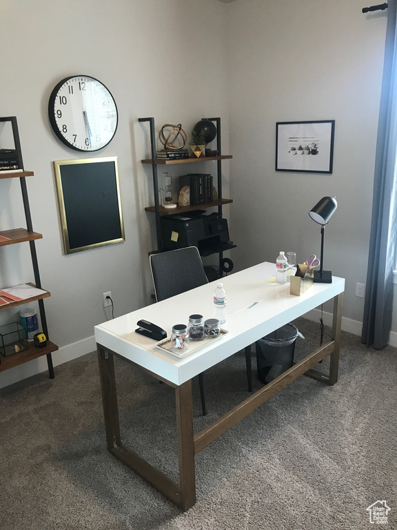 Carpeted office space with baseboards