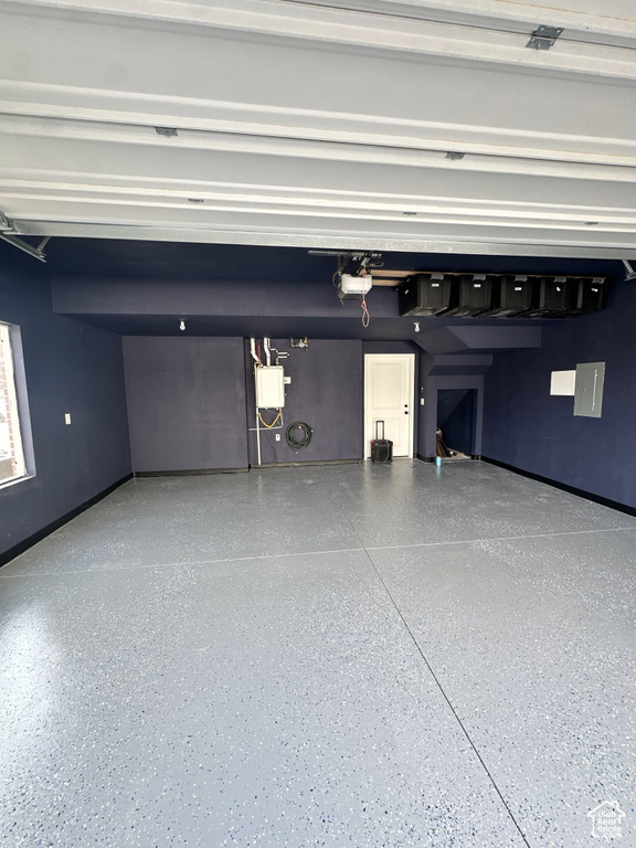 Garage with baseboards and a garage door opener