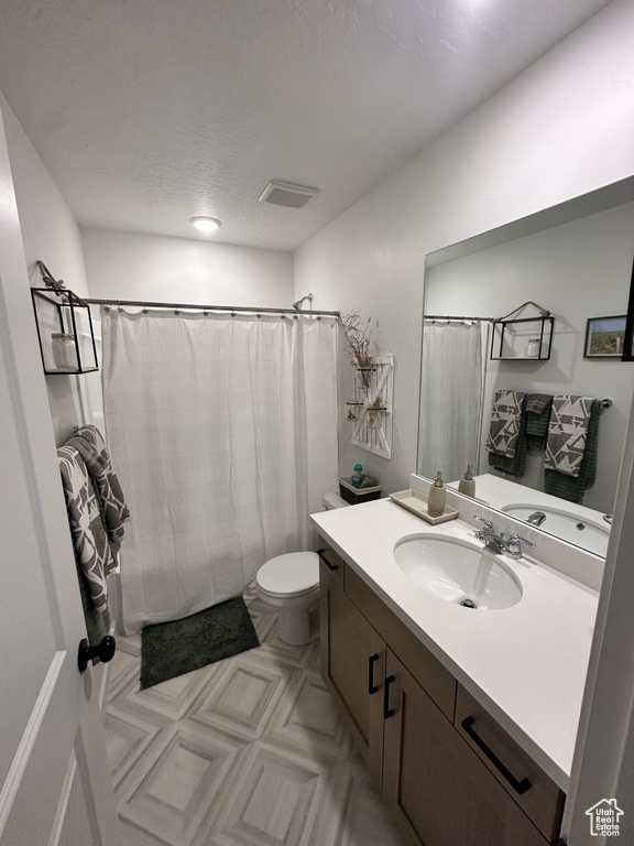 Full bathroom with visible vents, toilet, a shower with curtain, and vanity