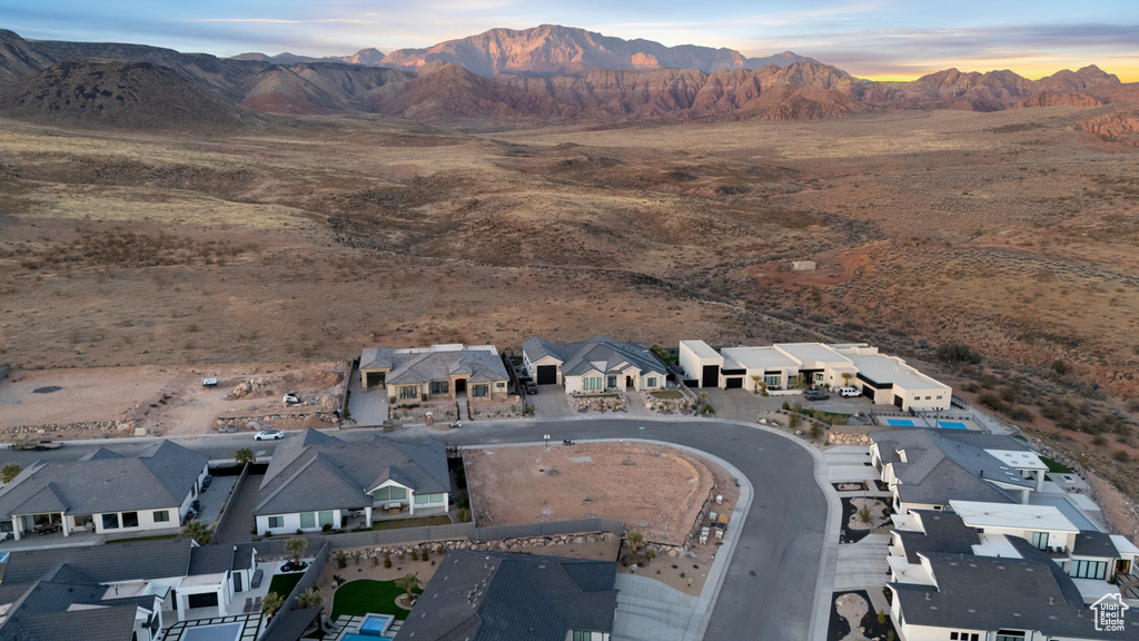 Aerial view at dusk featuring a mountain view, a residential view, and a desert view