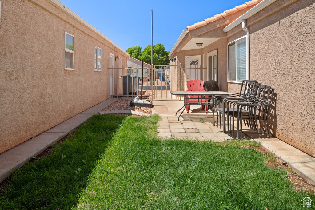 View of yard featuring a gate, fence, and a patio area
