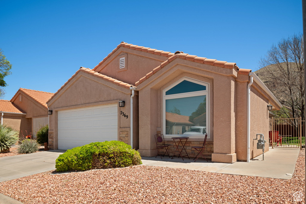 Single story home featuring stucco siding, concrete driveway, and an attached garage
