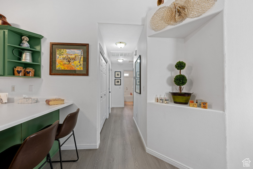 Hall featuring visible vents, baseboards, and light wood-type flooring