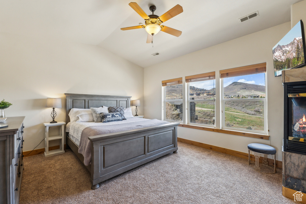Bedroom with light carpet, vaulted ceiling, and baseboards