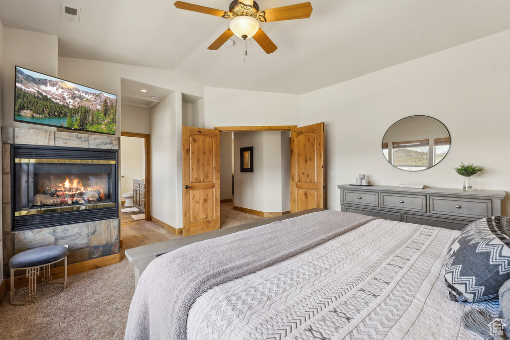 Carpeted bedroom featuring visible vents, ceiling fan, vaulted ceiling, and a fireplace