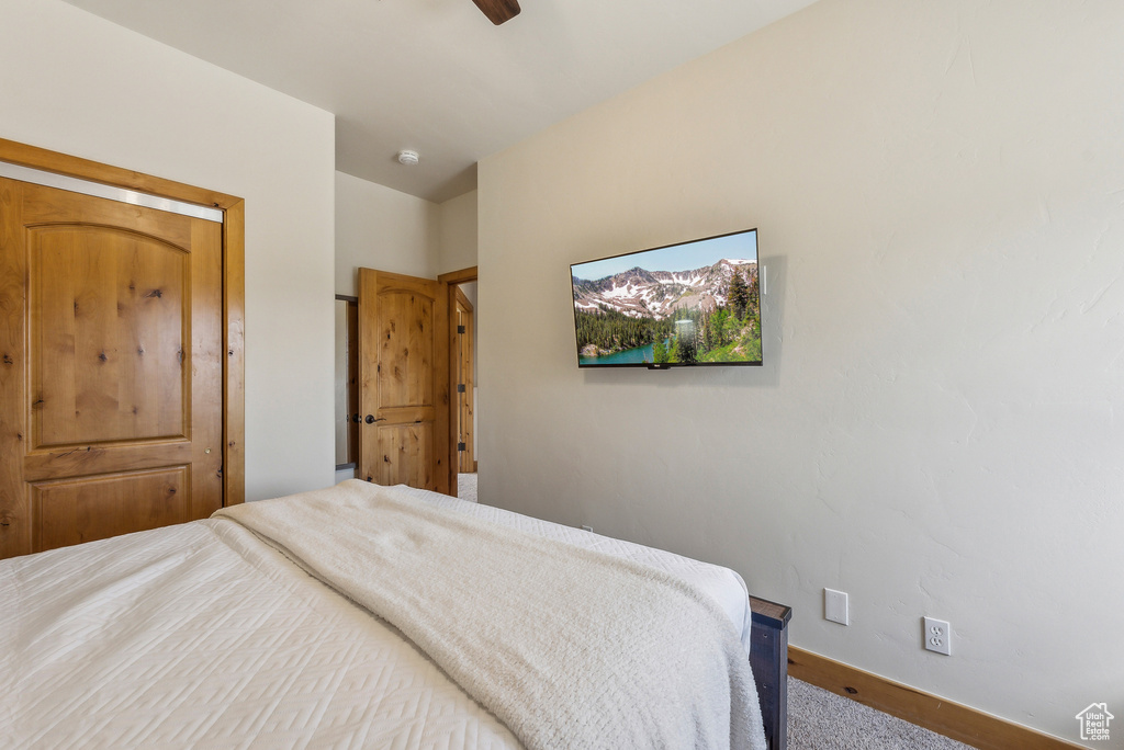 Carpeted bedroom featuring ceiling fan and baseboards